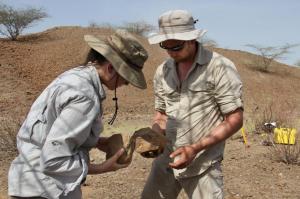 "In this undated photo made available in May 2015 by the Mission Prehistorique au Kenya - West Turkana Archaeological Project, Sonia Harmand and Jason Lewis hold stone tools found in the West Turkana area of Kenya. The artifacts, dated at 3.3 million years old, are much older than the earliest known trace of our own branch of the evolutionary family tree. So its a new challenge to the traditional idea that only members of our branch made stone tools. The discovery was reported in the journal Nature on Wednesday, May 20, 2015. (MPK-WTAP via AP)"